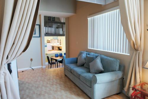 a living room with a blue couch and a table at Castle L1 Double-Loft Condo with Beach Access, Pool, Tennis and Free Parking! in Miami Beach
