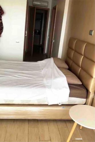 Una cama en una habitación con una mesa al lado en Appartements lux respectueux en Sidi Bouqnadel