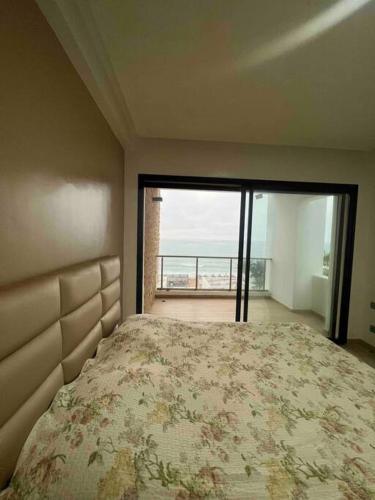 - une chambre avec un lit et une vue sur l'océan dans l'établissement Appartements lux respectueux, à Sidi Bouqnadel