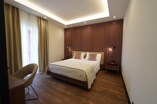 1 dormitorio con cama, escritorio y ventana en Re Di Cuori Hotel, en Caianello