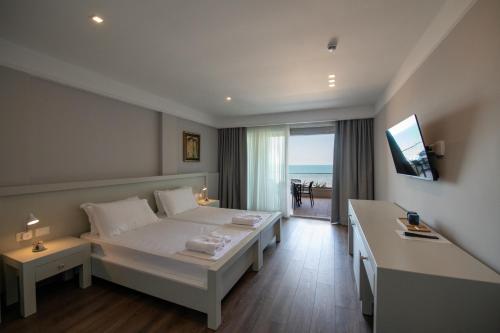 a bedroom with a bed and a view of the ocean at Hotel Vila 11 in Durrës