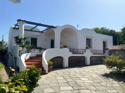 een wit huis met een trap en een hek bij La Pica Marina Anacapri in Anacapri