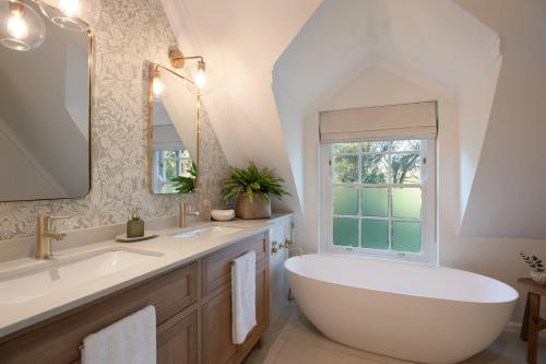 a bathroom with a large tub and a window at Mount Vernon Manor in Klapmuts