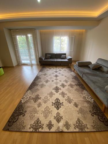 a living room with a couch and a rug at Bornova nezih ferah Yıllık-Aylık_Haftalık in Burunabat