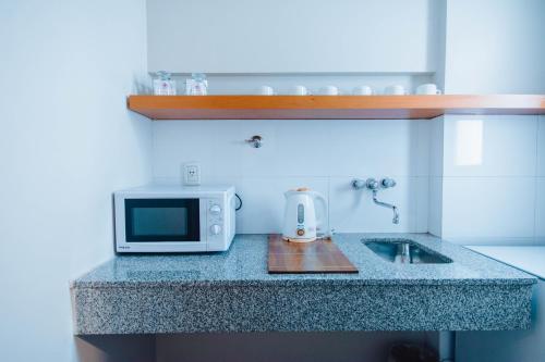a kitchen counter with a microwave and a sink at Hotel Spa Republica in Mar del Plata