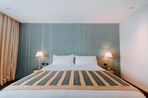a bedroom with a large bed with two lamps at Hotel Spa Republica in Mar del Plata