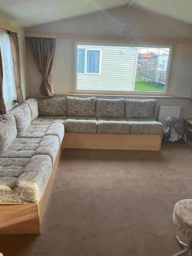 a large couch sitting in a living room at Fantasy Island, Sunnymede 8 Berth in Ingoldmells