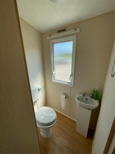 a small bathroom with a toilet and a sink at Fantasy Island, Sunnymede 8 Berth in Ingoldmells