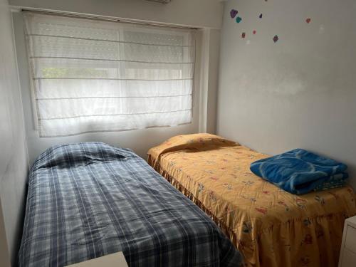 2 camas en un dormitorio con ventana en Departamento de 3 ambientes Caballito en Buenos Aires