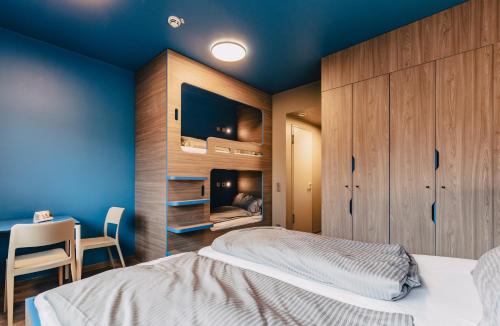 a bedroom with a bed and a desk with a chair at Jugendherberge München City in Munich