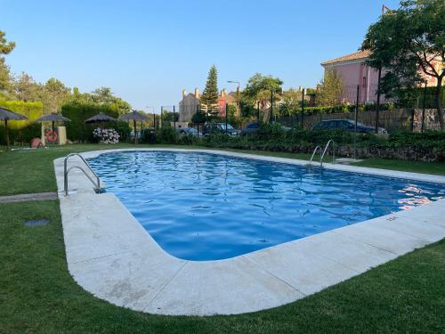 una piscina de agua azul en un patio en Apartamento Green Golf Islantilla, en Islantilla