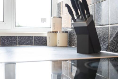 a knife block sitting on a counter in a kitchen at Admiral - 2 Bedroom Flat With Parking in Southampton
