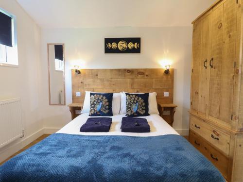 a bedroom with a large bed with a blue blanket at Juniper in Swadlincote