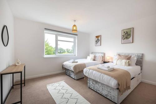 a bedroom with two beds and a window at Admiral - 2 Bedroom Flat With Parking in Southampton