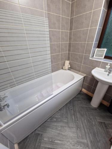 un bagno con vasca e lavandino di Chimes-Company & Family Stay, 2 Bedroom House + Free parking a Tamworth
