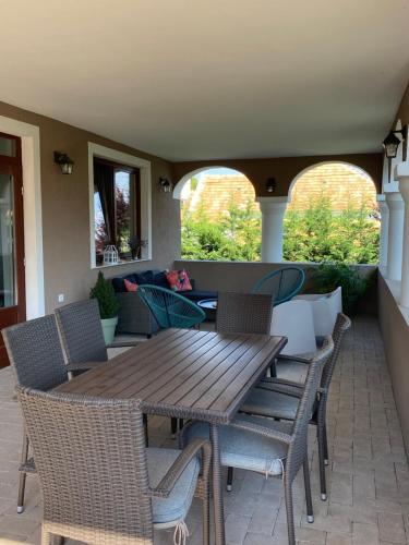 a wooden table and chairs on a patio at Oázis apartmanház in Fertőszentmiklós