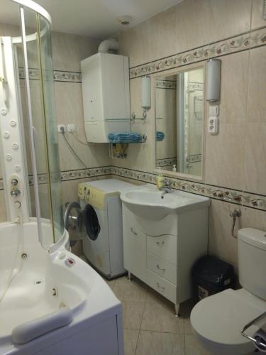 ein Badezimmer mit einem Waschbecken, einem WC und einem Spiegel in der Unterkunft Tókert Apartman in Ráckeve