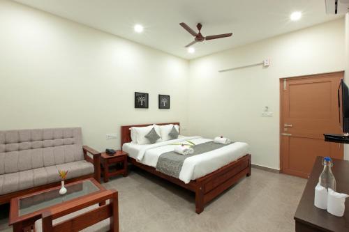 1 dormitorio con 1 cama y 1 sofá en GREEN PLANET HOTEL, en Mattanūr
