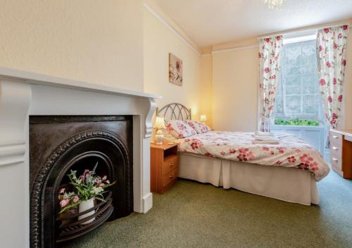 a bedroom with a fireplace and a bed at Courtney - Upcott House in Barnstaple