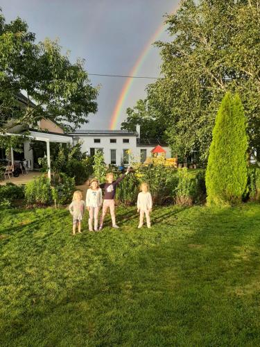 a group of four people standing in a yard with a rainbow at Chalet im Spiel- und Obstgarten in Keidelheim