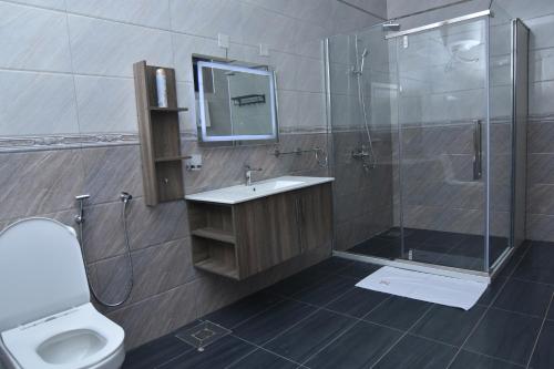 a bathroom with a shower and a sink and a toilet at Hotel Next in Masaka