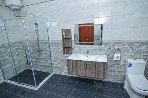 W łazience znajduje się prysznic, umywalka i toaleta. w obiekcie Hotel Next w mieście Masaka