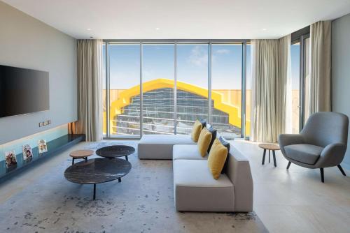 a living room with a couch and a large window at The WB Abu Dhabi, Curio Collection By Hilton in Abu Dhabi
