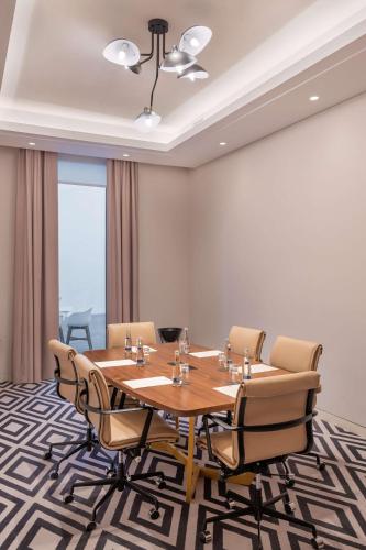 a conference room with a wooden table and chairs at The WB Abu Dhabi, Curio Collection By Hilton in Abu Dhabi