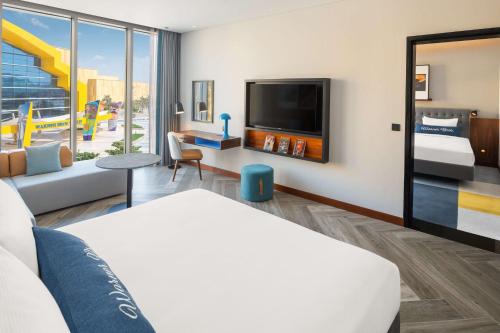 a hotel room with a bed and a flat screen tv at The WB Abu Dhabi, Curio Collection By Hilton in Abu Dhabi
