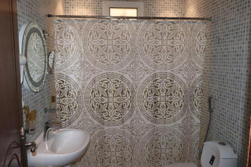 a bathroom with a shower curtain and a sink at Al Bateel Furnished Apartments in Riyadh