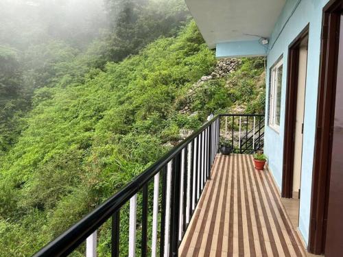 a balcony of a house with a view of a mountain at 100 stairs holiday home in Mussoorie