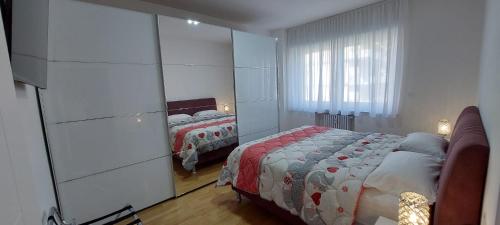 1 dormitorio con cama y espejo grande en Appartamento Laura, en Merano
