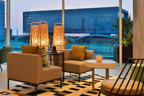 a lobby with chairs and tables and a large window at Hilton Garden Inn Bahrain Bay in Manama