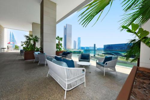 a hotel lobby with chairs and a view of the city at Hilton Garden Inn Bahrain Bay in Manama