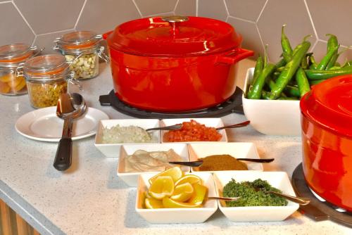 a counter with dishes of food and a red pot at Hilton Garden Inn Bahrain Bay in Manama