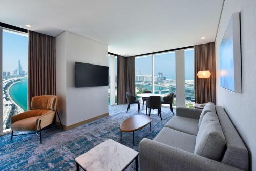 a living room with a couch and a table with chairs at Hilton Garden Inn Bahrain Bay in Manama