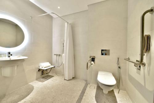 uma casa de banho branca com um WC e um lavatório em Hilton Garden Inn Bahrain Bay em Manama