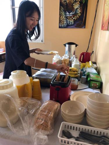 a woman standing in a kitchen preparing food at Yellow Belly Backpackers in San Ignacio
