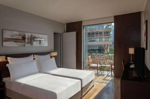 een slaapkamer met een bed en een groot raam bij Hilton Beirut Downtown in Beiroet