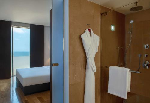 a white dress hanging on a wall in a bathroom at Hilton Beirut Downtown in Beirut