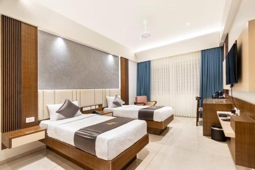 a hotel room with two beds and a desk at Narthaki Boutique Hotel in Bengaluru