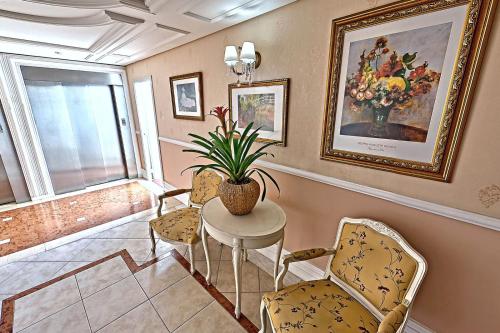 a living room with a table and chairs and a painting at Hotel Firenze in Serra Negra
