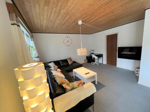 a living room with a couch and a table at The Yellow House, Beach 5mins Drive, 3BR with free parking, Fast Fiber Internet in Rødby