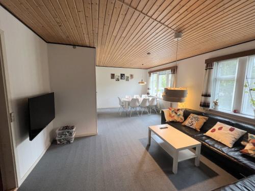 a living room with a couch and a tv at The Yellow House, Beach 5mins Drive, 3BR with free parking, Fast Fiber Internet in Rødby