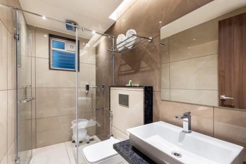 a bathroom with a sink and a glass shower at Narthaki Boutique Hotel in Bengaluru