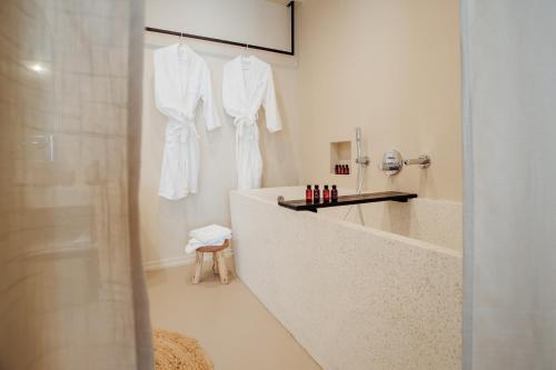 a white bathroom with a tub and a sink at Thymises Boutique Hotel in Kakopetria