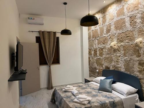 una camera con letto e muro di mattoni di Lapis rooms a Pachino