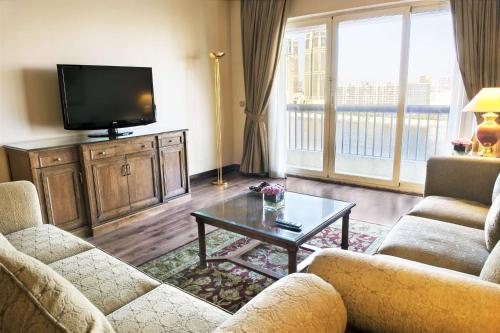 a living room with two couches and a tv at Hilton Cairo Zamalek Residences in Cairo