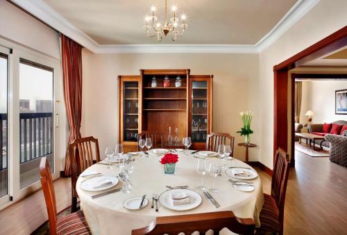 a dining room with a table with plates and wine glasses at Hilton Cairo Zamalek Residences in Cairo