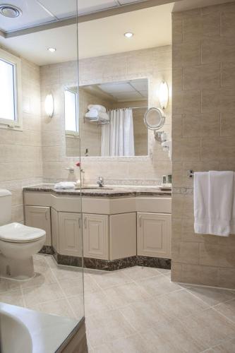 a bathroom with a toilet and a sink and a mirror at Hilton Cairo Zamalek Residences in Cairo